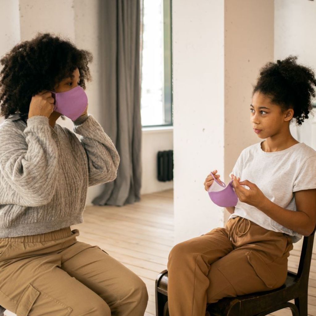 mother and teen daughter trying on masks