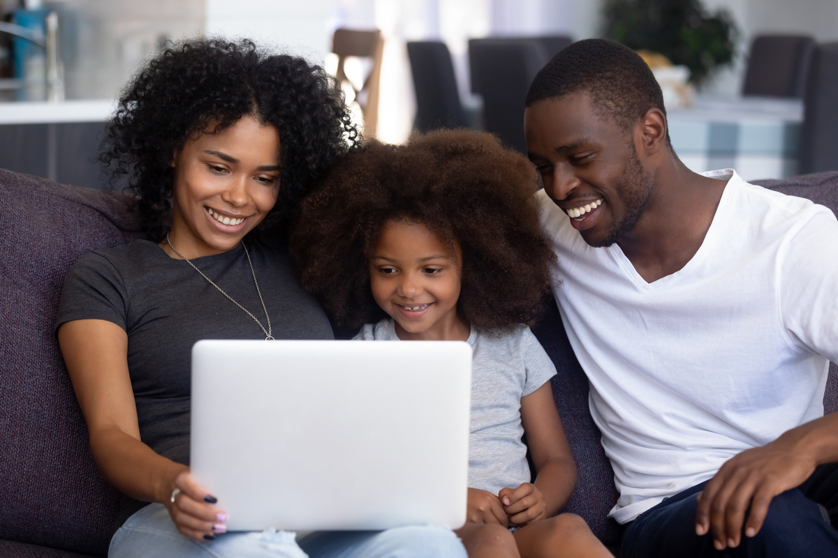 A family gathered around the computer booking a trip