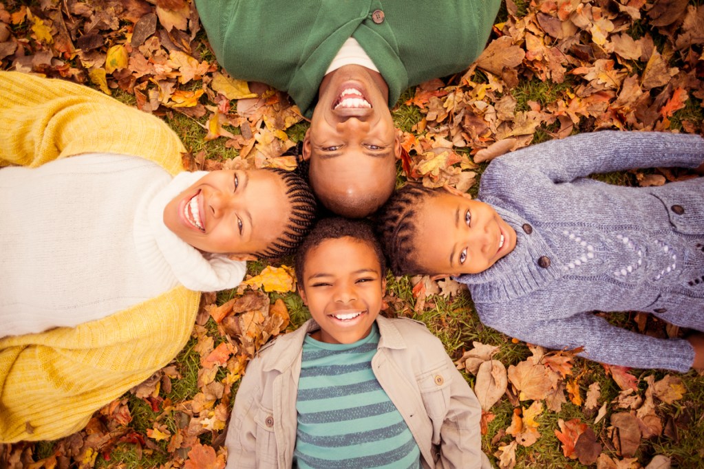 A family enjoying lying in the leaves.