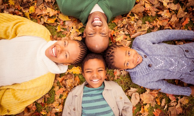 A family enjoying lying in the leaves.