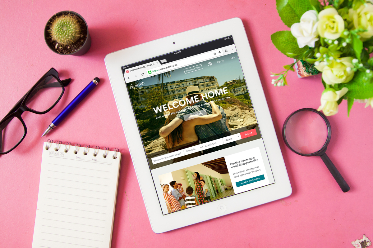 A tablet and other office items on a pink background.