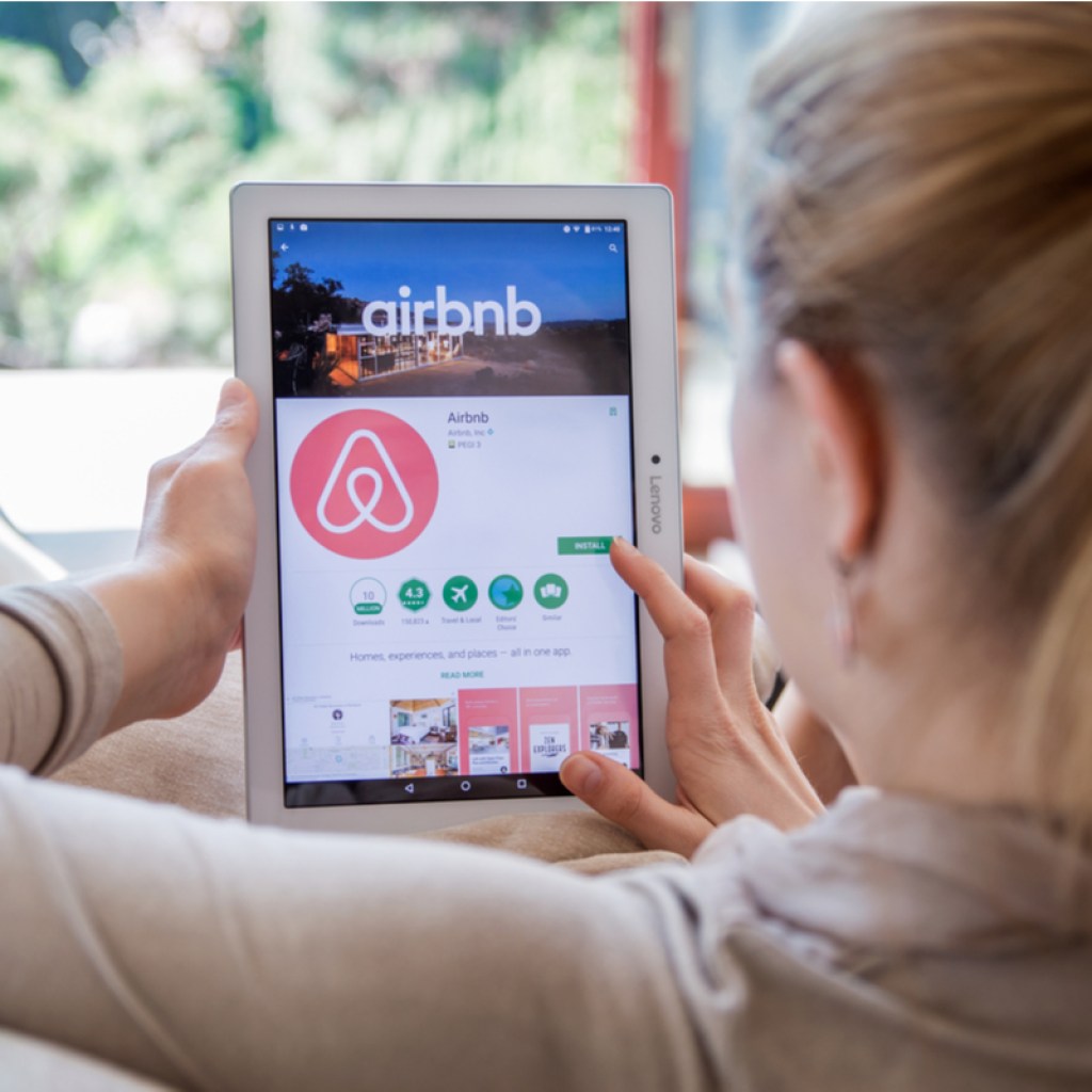 A woman looking up a place to stay on Airbnb.