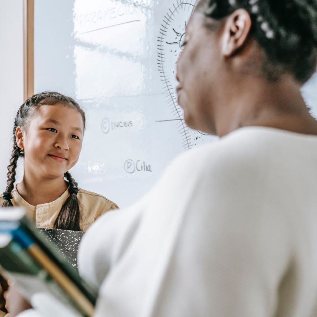 student and teacher talking in classroom