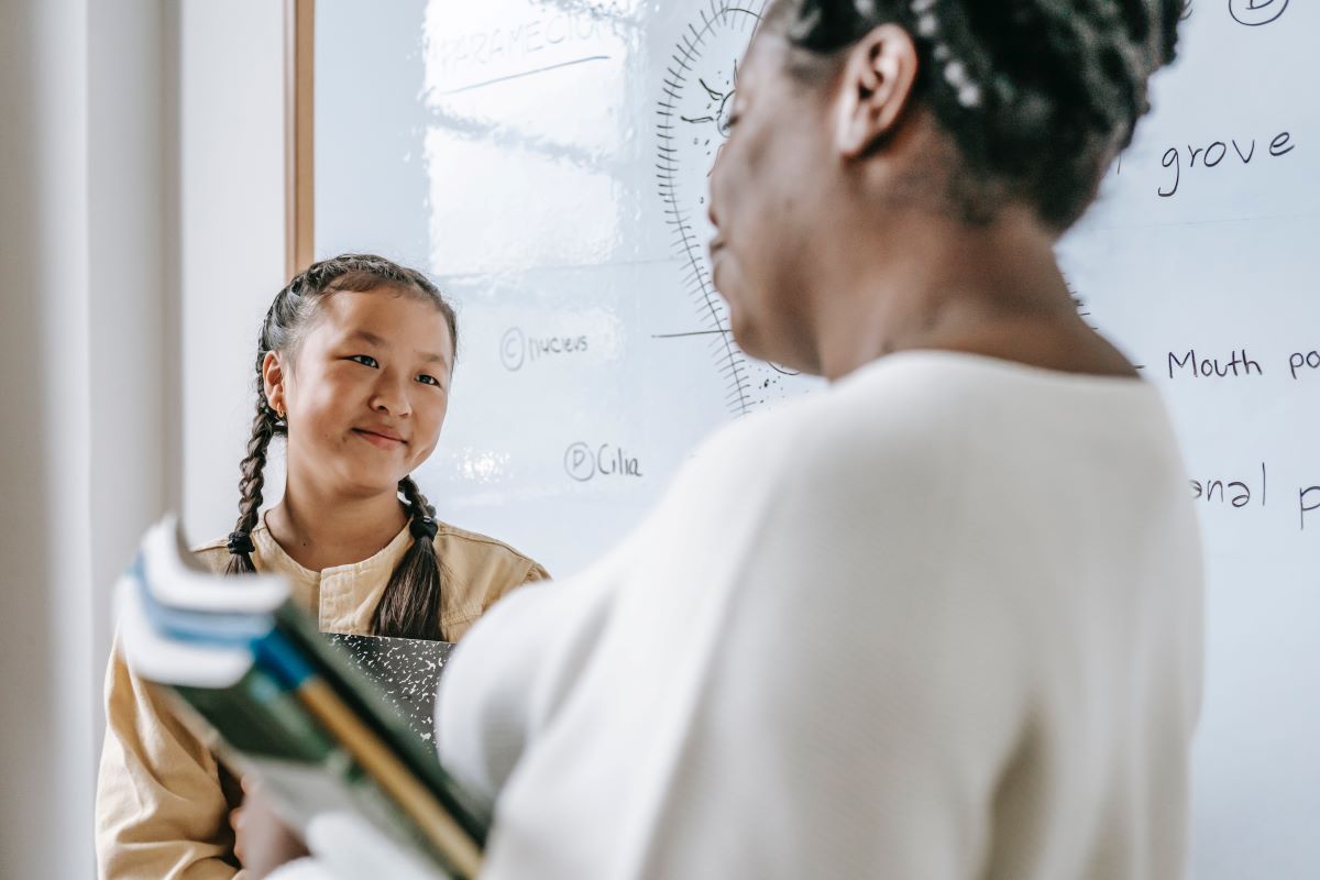 student and teacher talking in classroom