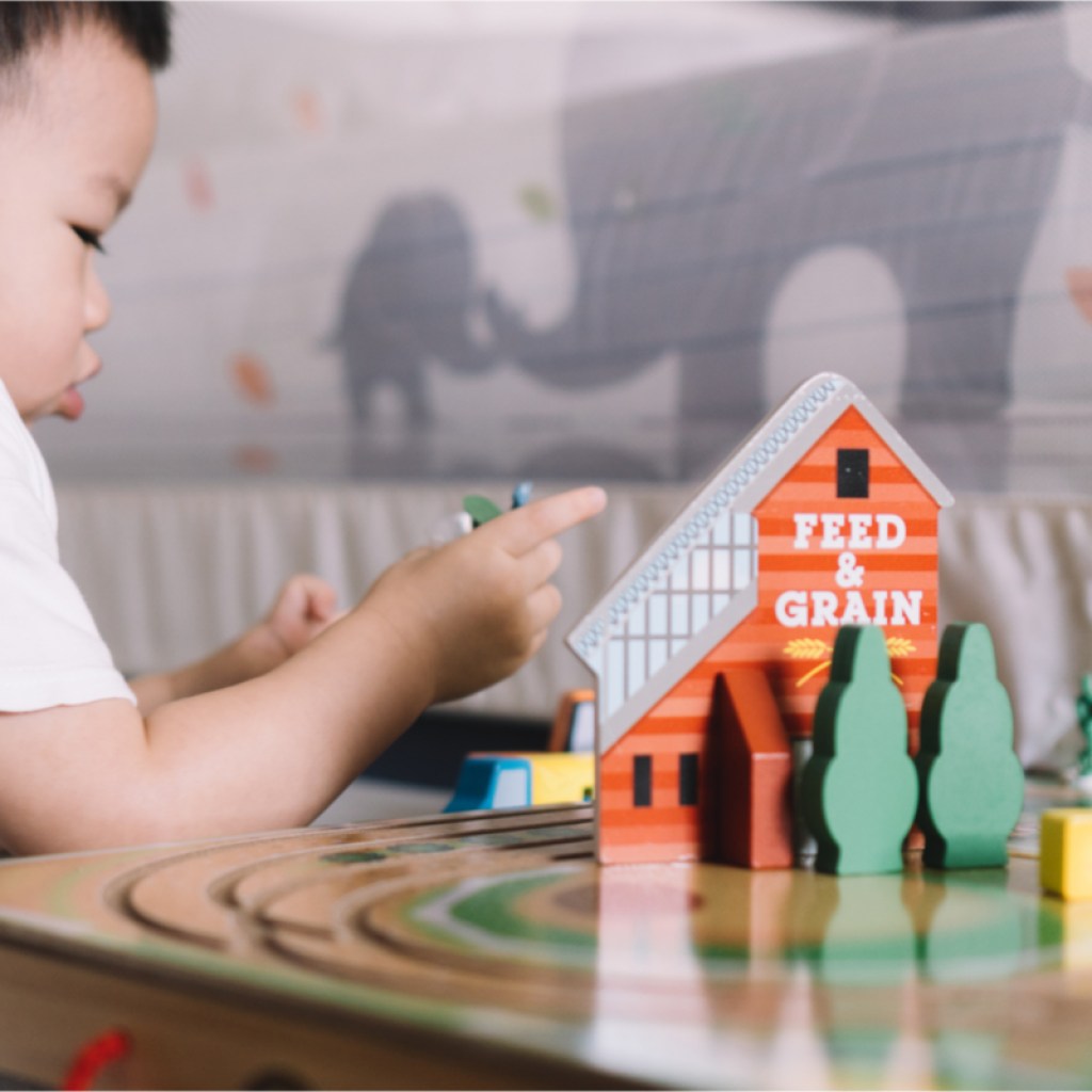 Toddler boy having fun with farm toys