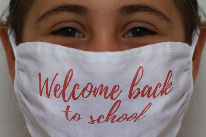 child wearing a welcome back mask