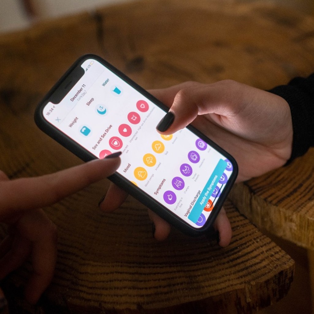 woman putting data into a menstrual cycle app