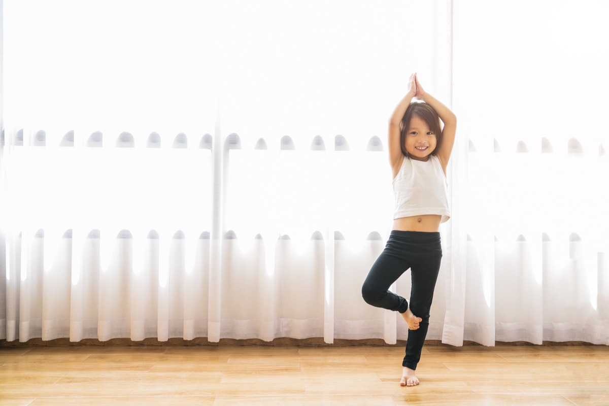 Little girl doing yoga poses as an exercise warm-up.