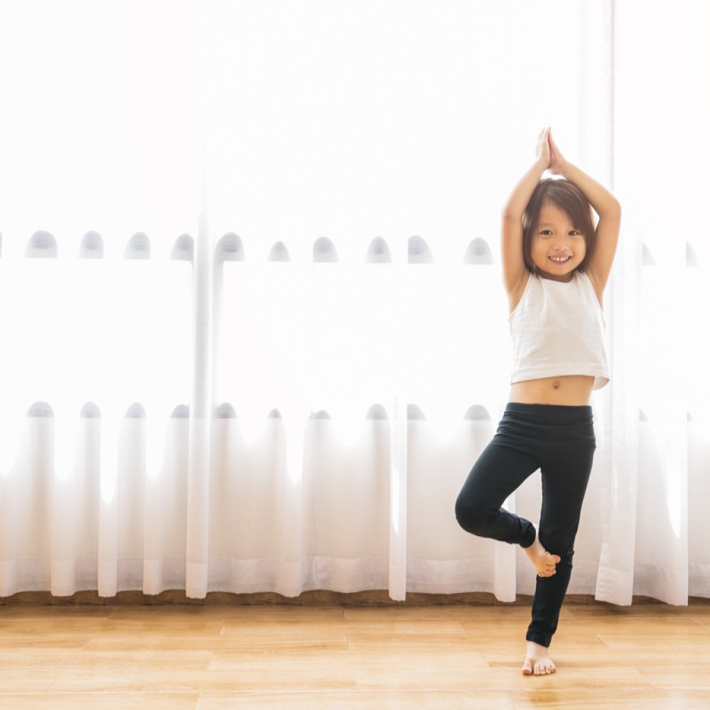 Little girl doing yoga poses as an exercise warm-up.