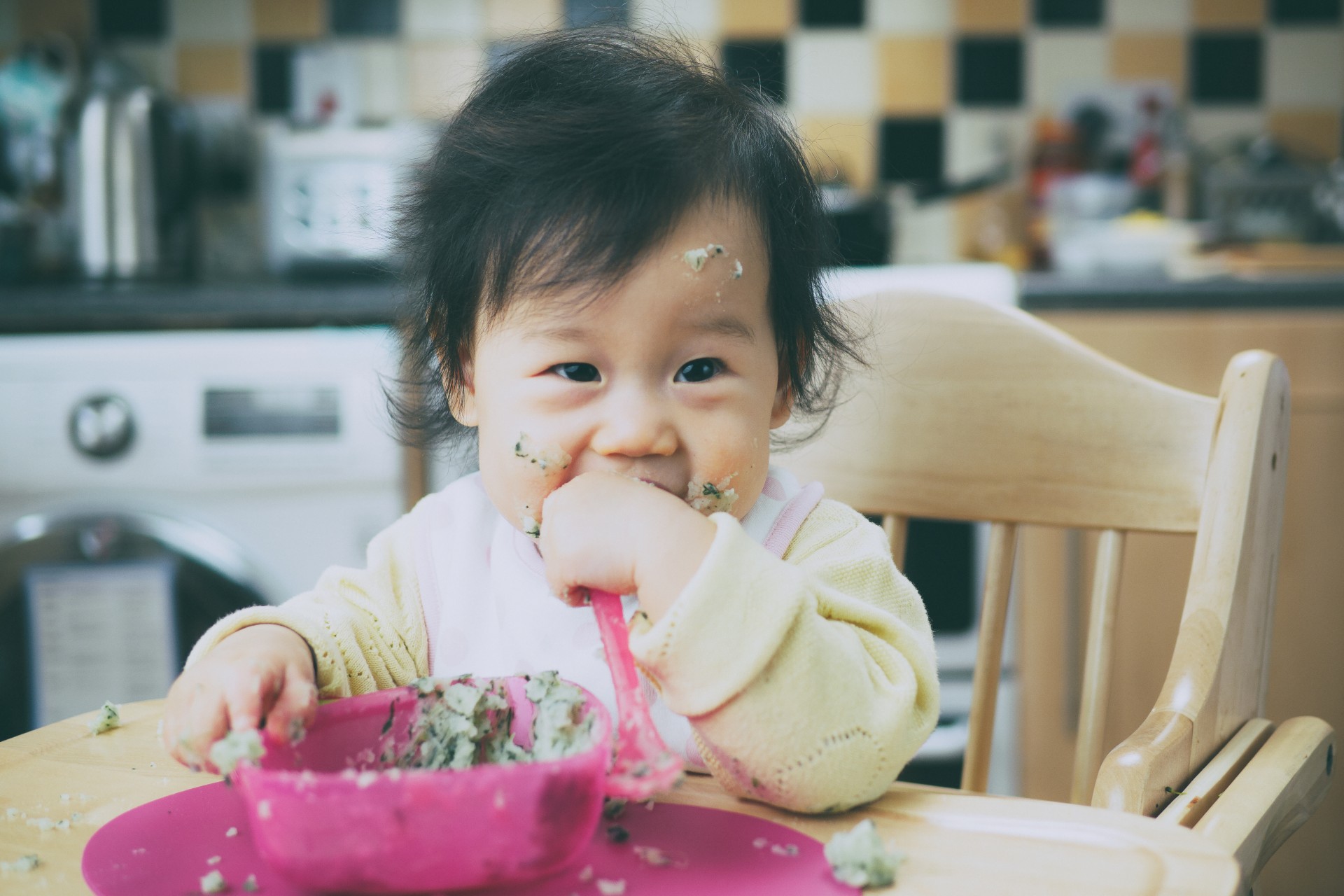 A child in a high chair to eat.