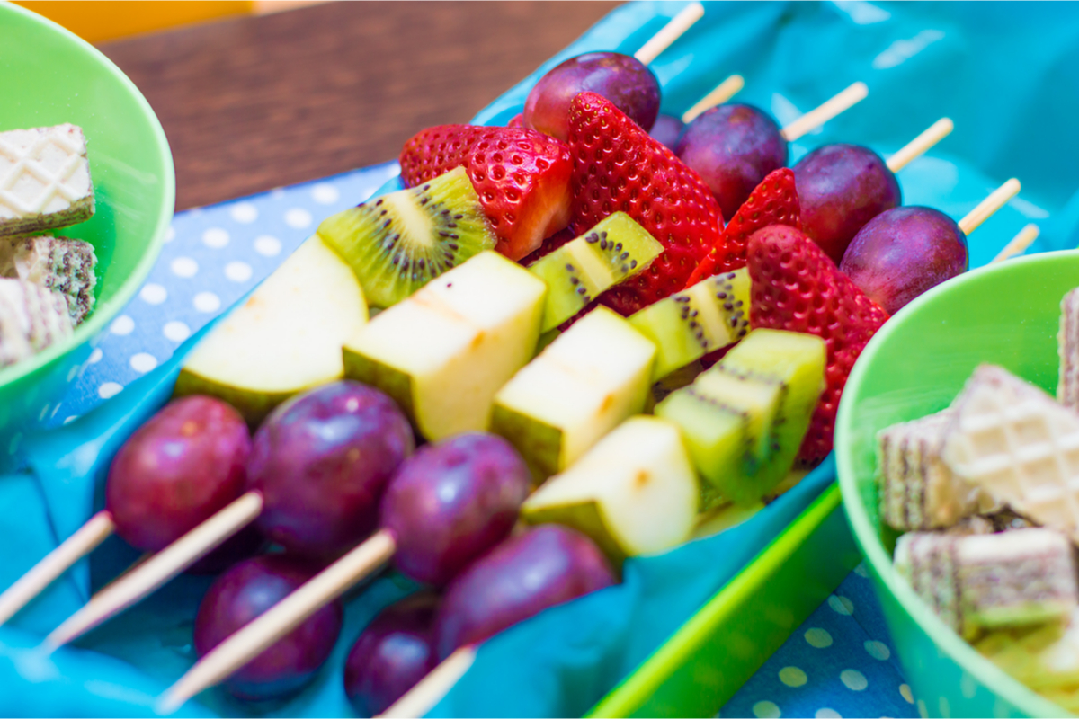 healthy birthday fruit kabobs on the party table