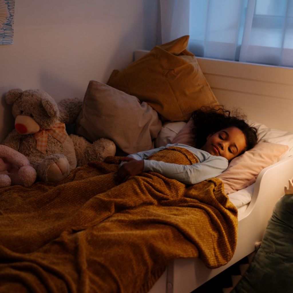 little girl sleeping in toddler bed