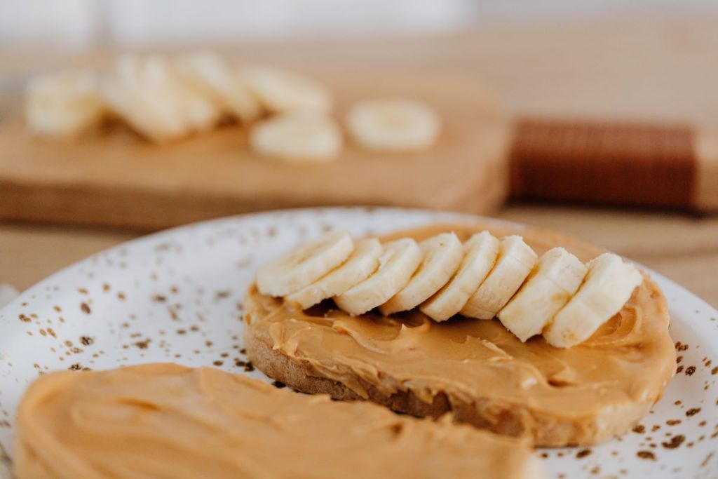 Two slices of bread with peanut butter and bananas