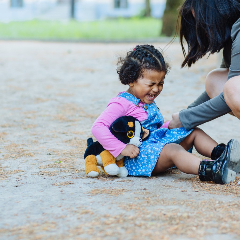 A toddler throwing a fit at a park.