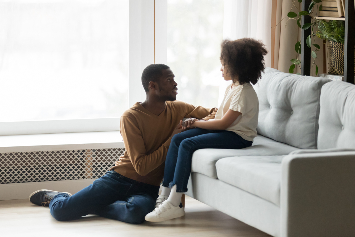 A father comforting and talking to his daughter.