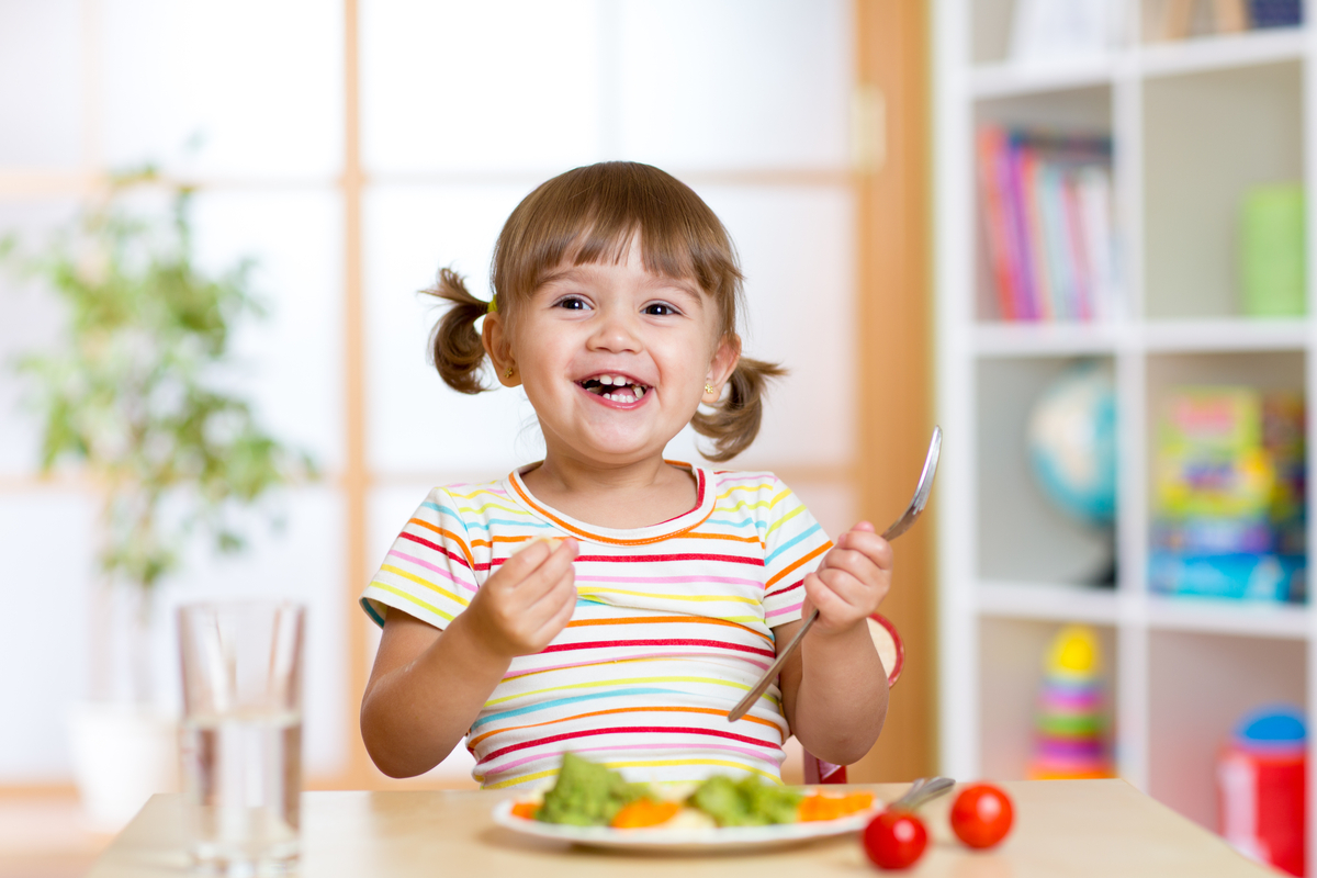 A young girl enjoying her dinner.