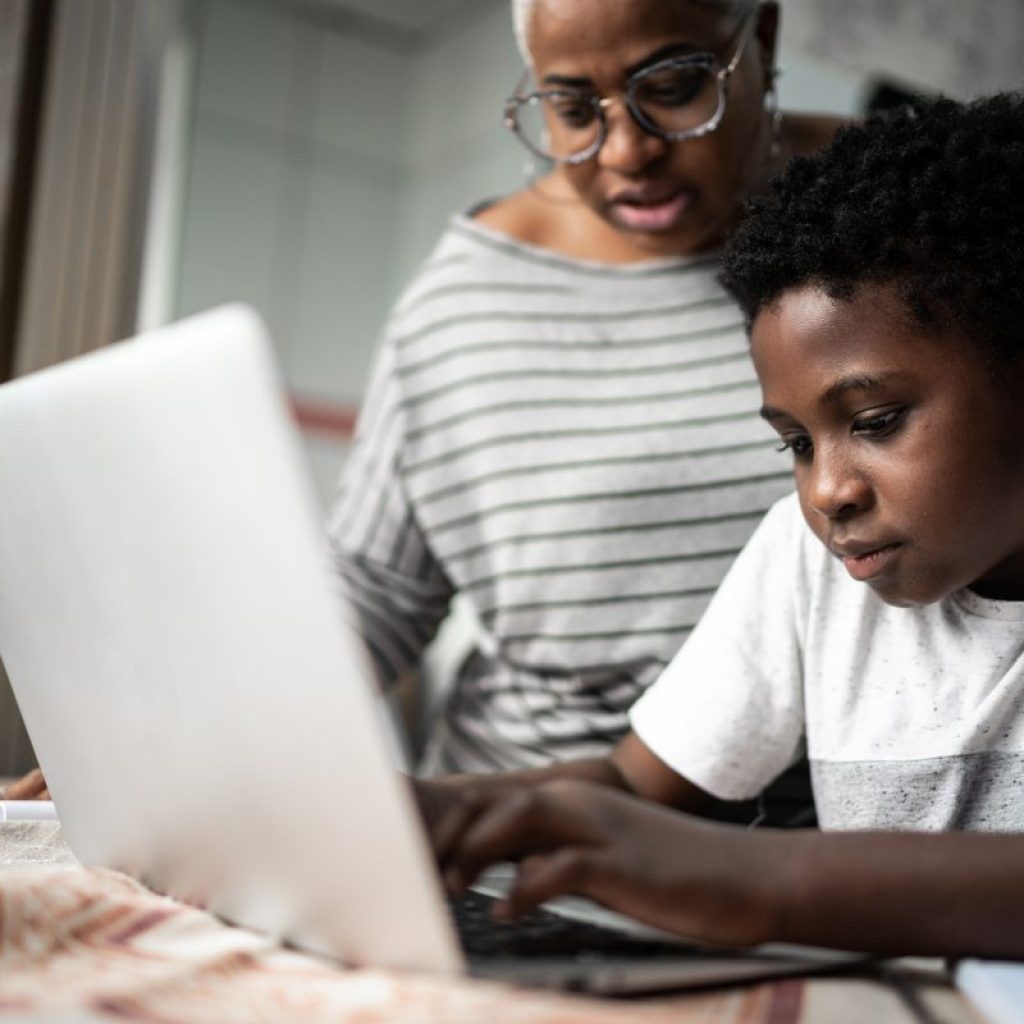 Parent helping a child on the laptop