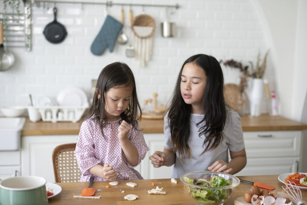 Two children are making a snack in the kitchen