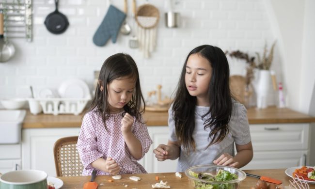 Two children are making a snack in the kitchen