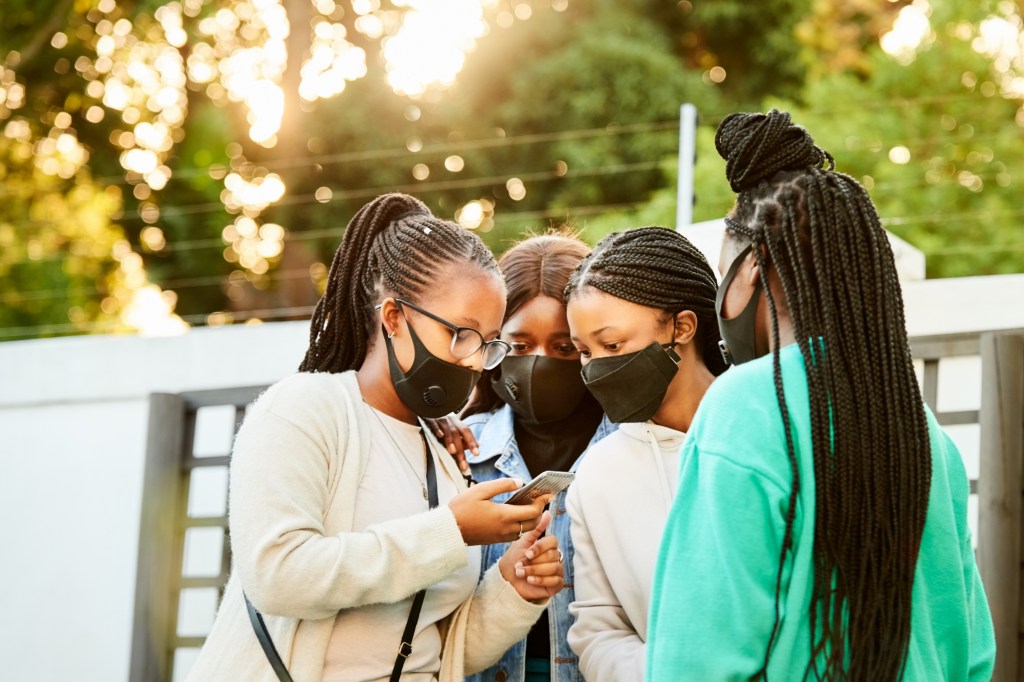 teen-girls-discuss-coronavirus-looking-at-phones