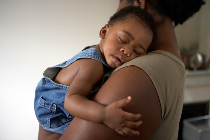 Infant sleeping on mother's shoulder