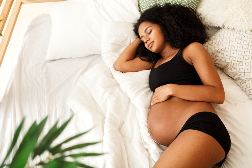 Pregnant woman sleeping on a bed