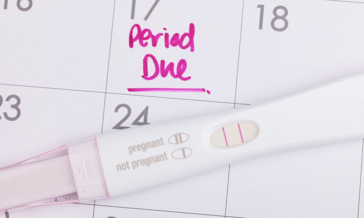 Pregnancy test on top of a calendar