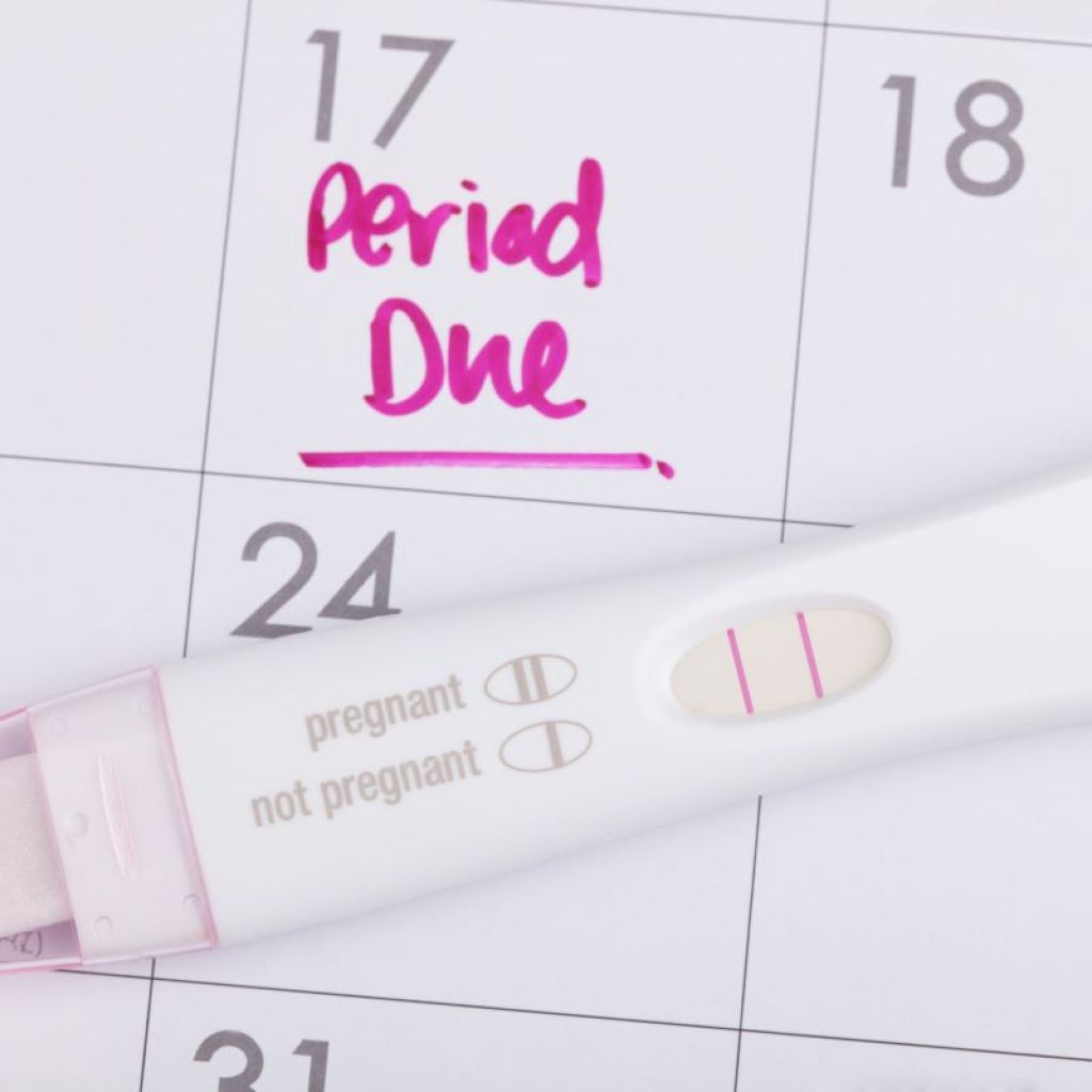 Pregnancy test on top of a calendar