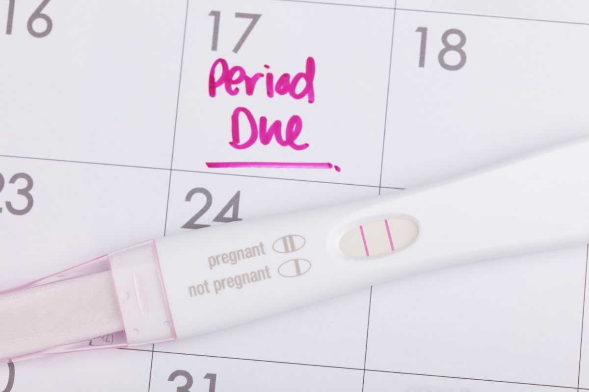 Pregnancy test on top of a calendar