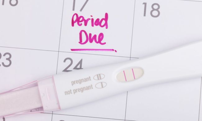 Pregnancy test on top of a calendar
