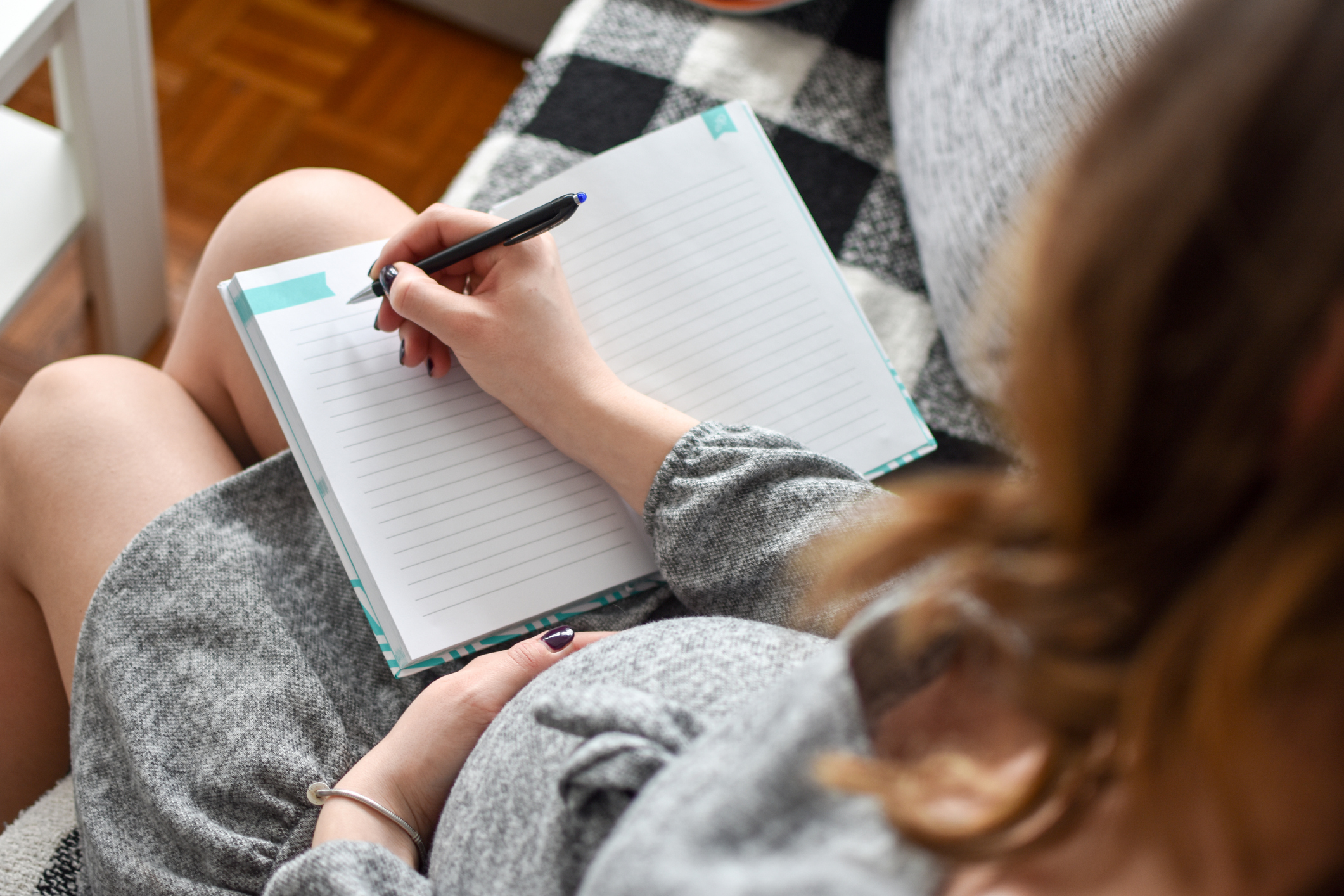 Pregnant woman writing in a notebook.