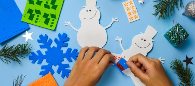 Hands putting together a snowman craft