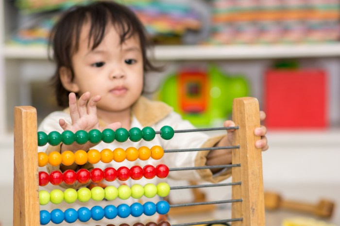 toddler learning to count with an abacus