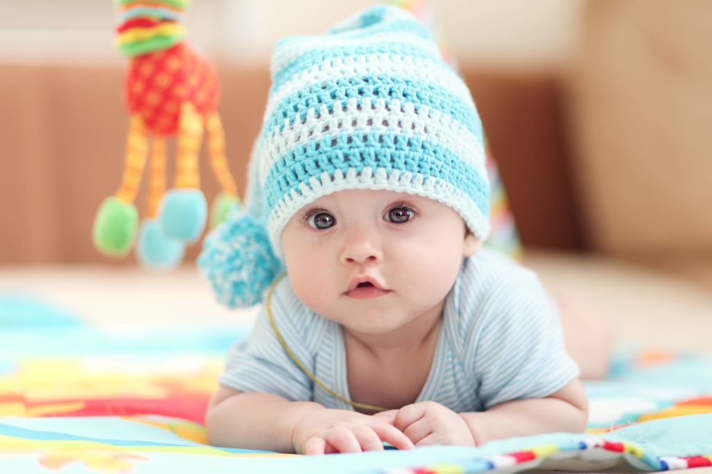 Baby boy wearing a blue knitted cap.