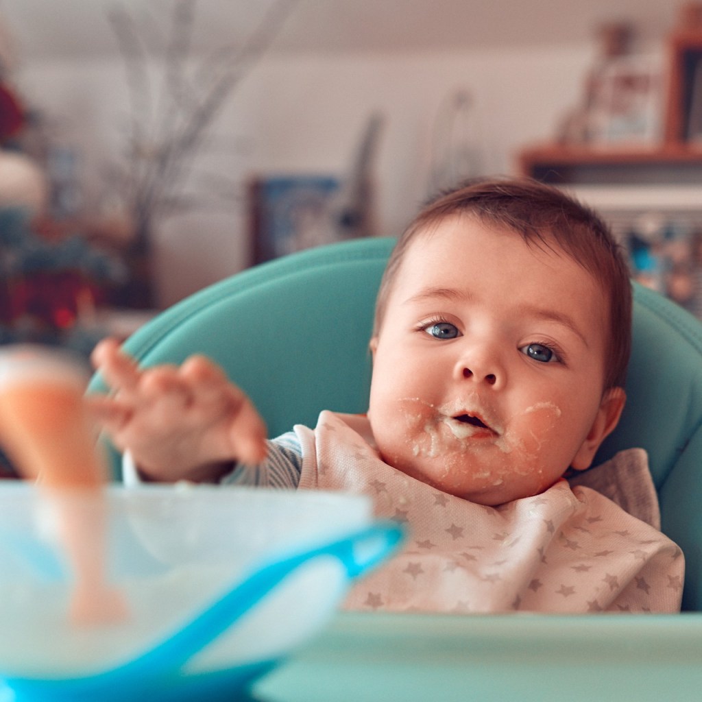 Baby eating in a highchair during Christmas