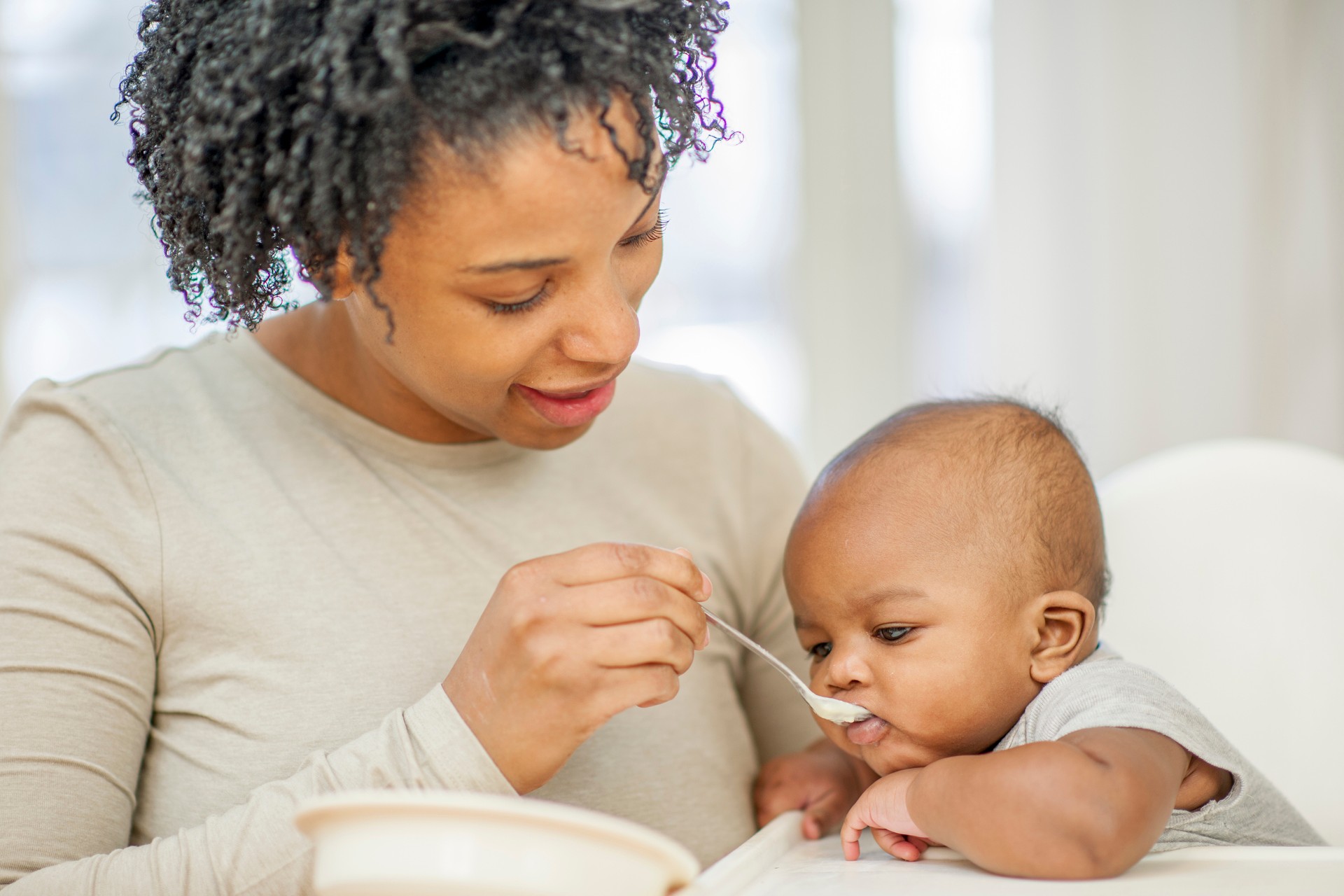 A parent feeding a baby.