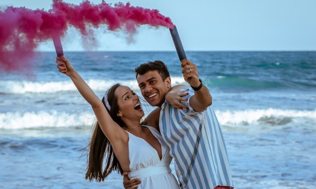 a couple on a beach celebrating gender reveal of a girl