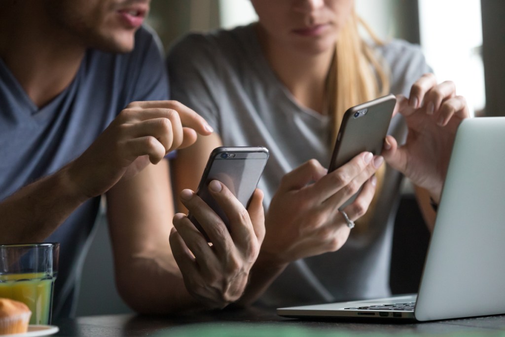 couple using family money saving app on their smartphones
