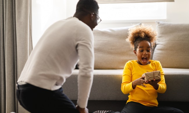 Girl is excited about getting a Christmas present from her father.