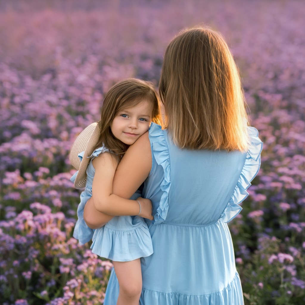 Mother holding daughter in a field of flowers