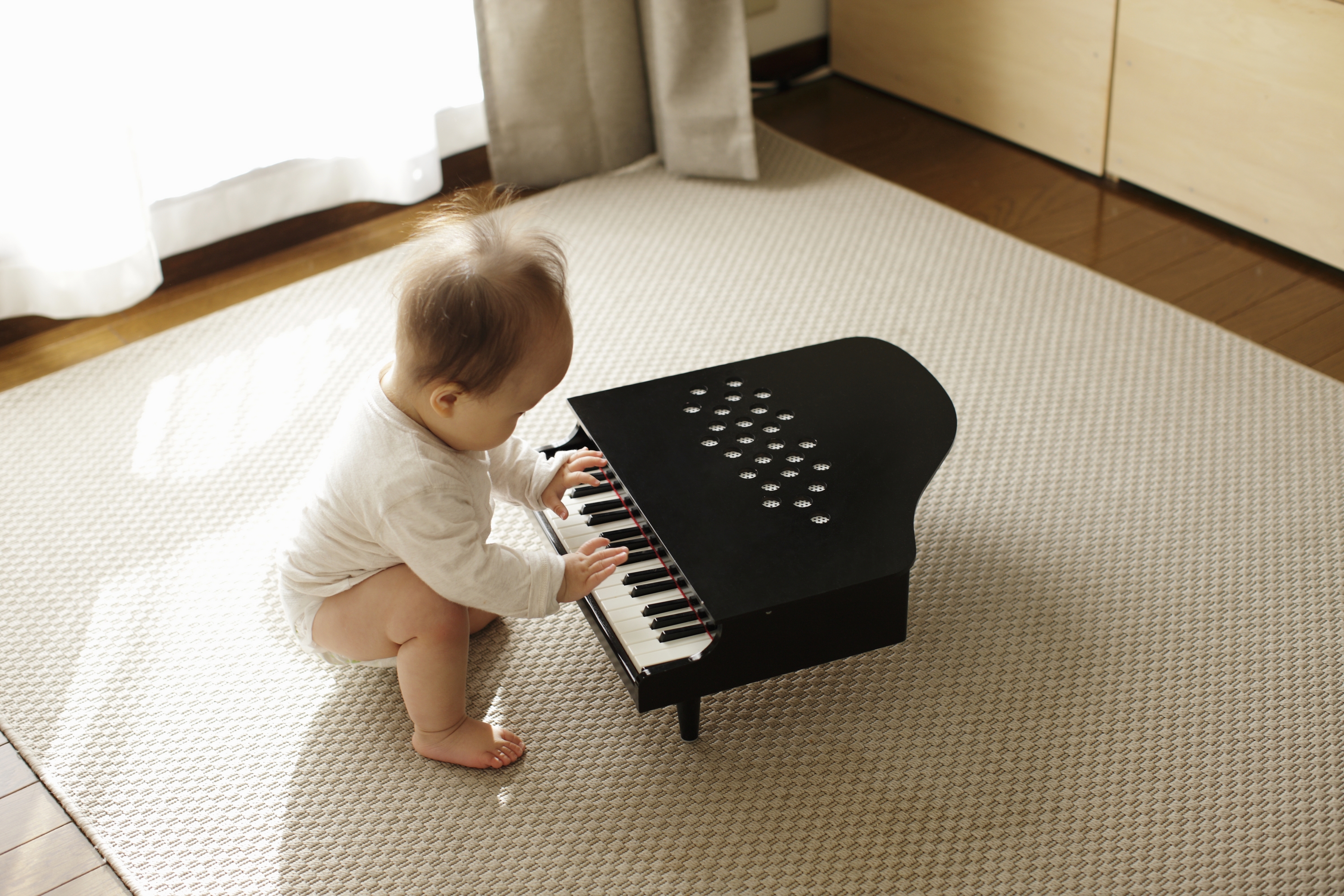 A baby playing a little piano.
