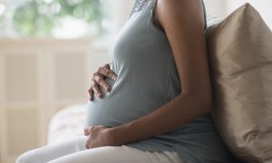 Pregnant woman cradling baby bump