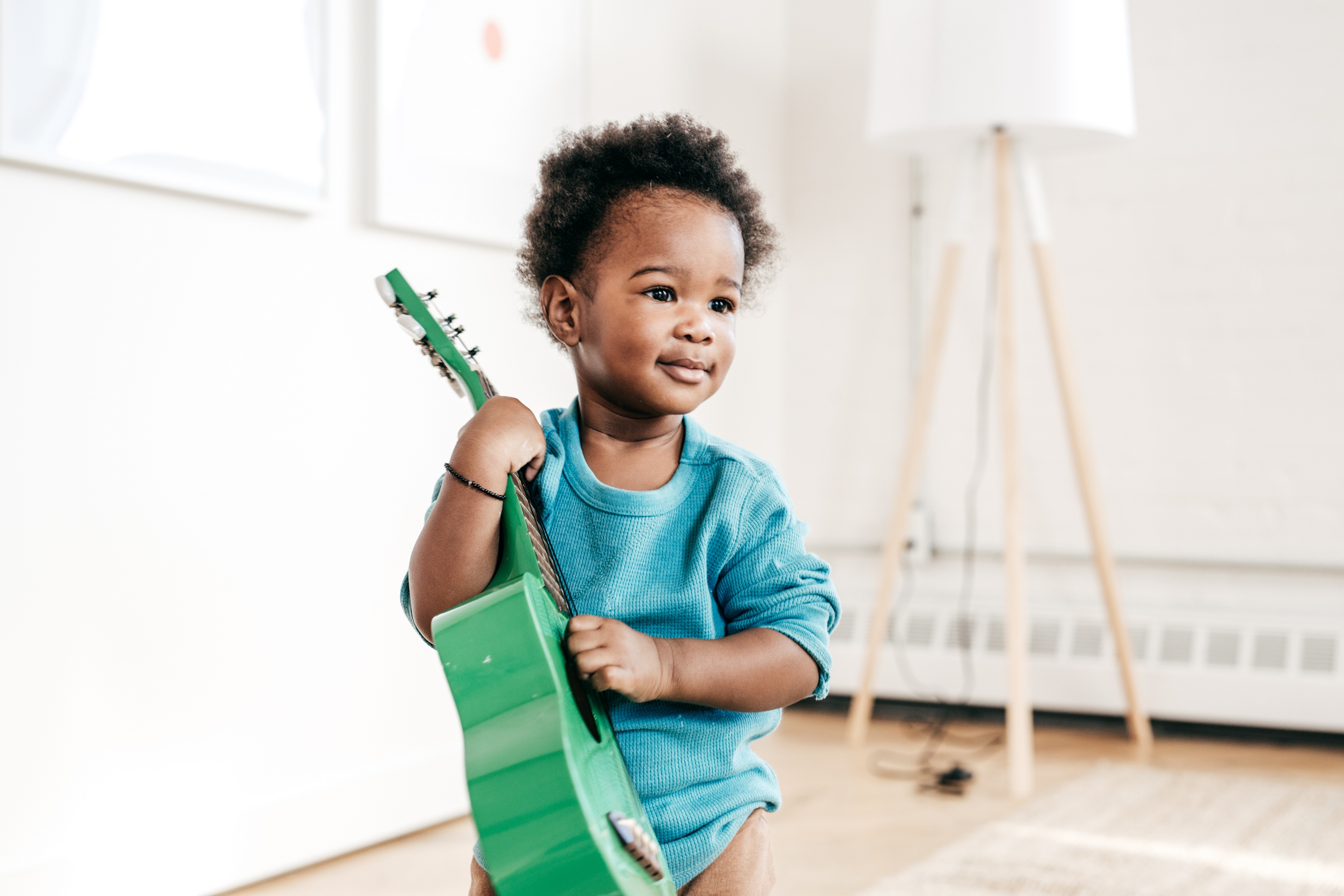 Child holding a toy guitar.