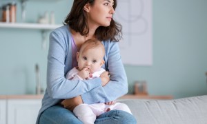 woman looking out window with baby