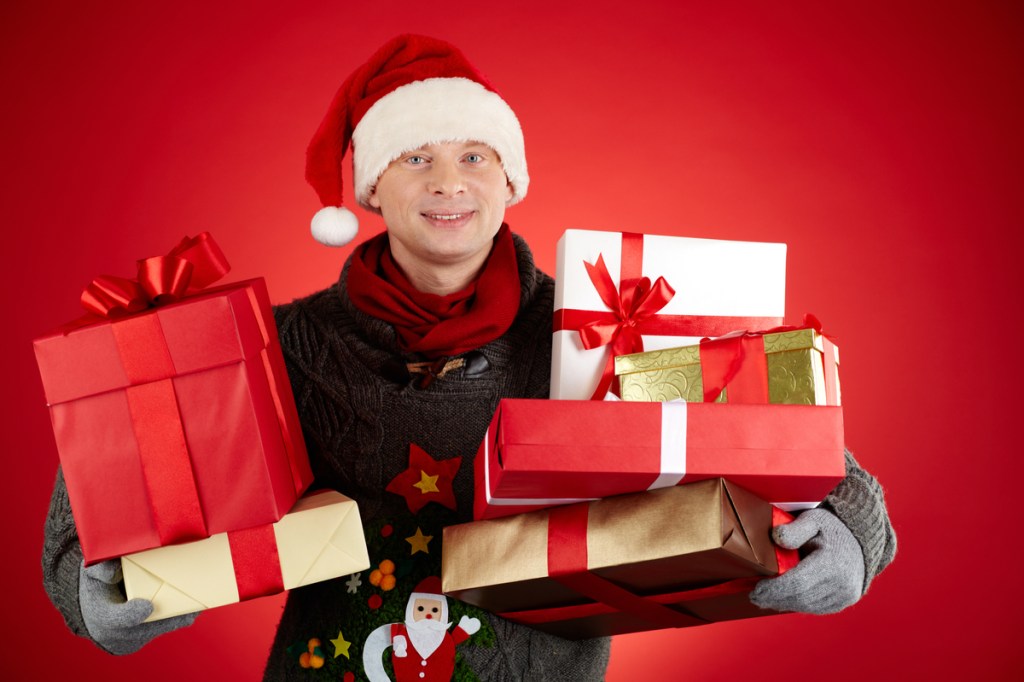 A young man holding Christmas packages.