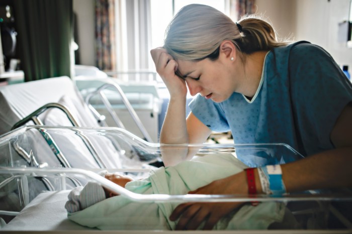 postpartum depression or baby blues sad and depress mother with her newborn at the