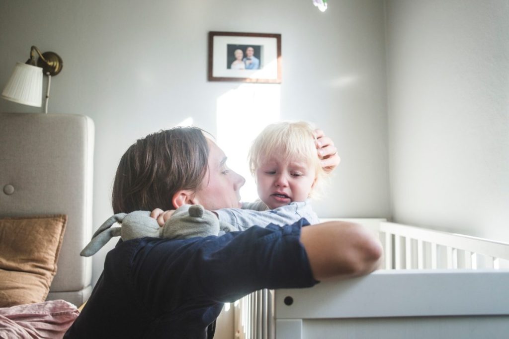 Toddler being comforted in bed after a nightmare.