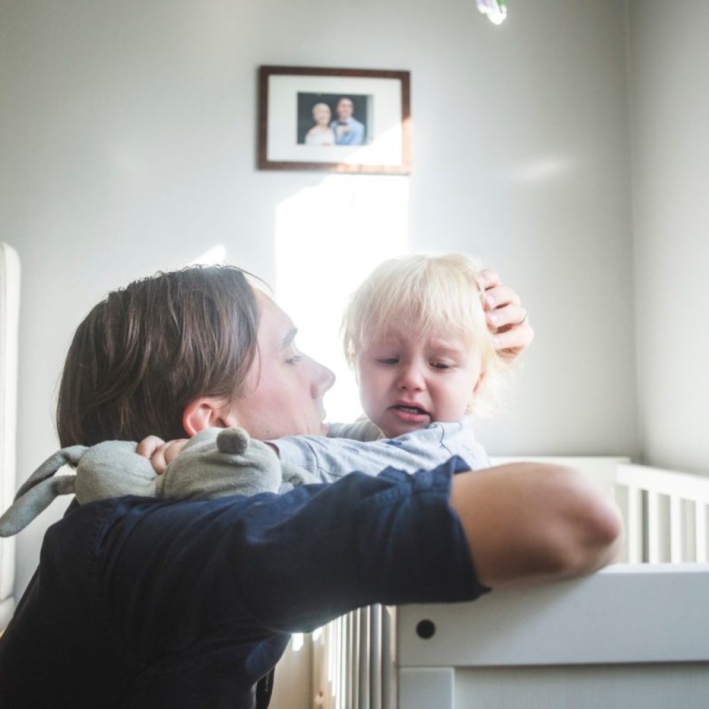 Toddler being comforted in bed after a nightmare.