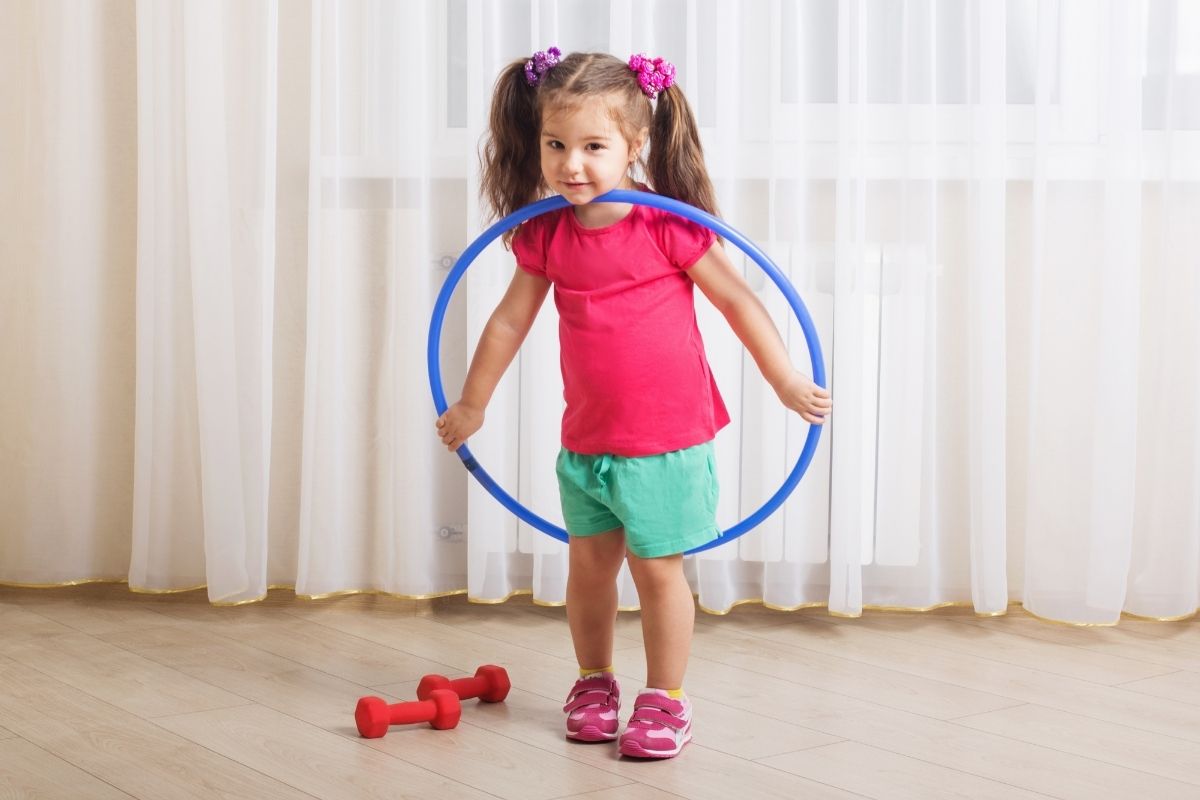 Little girl with hula hoop and weights