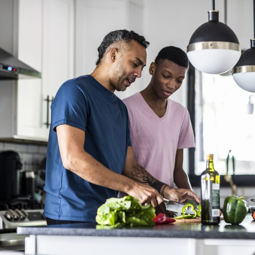 Parent and older child in the kitchen prepping dinner